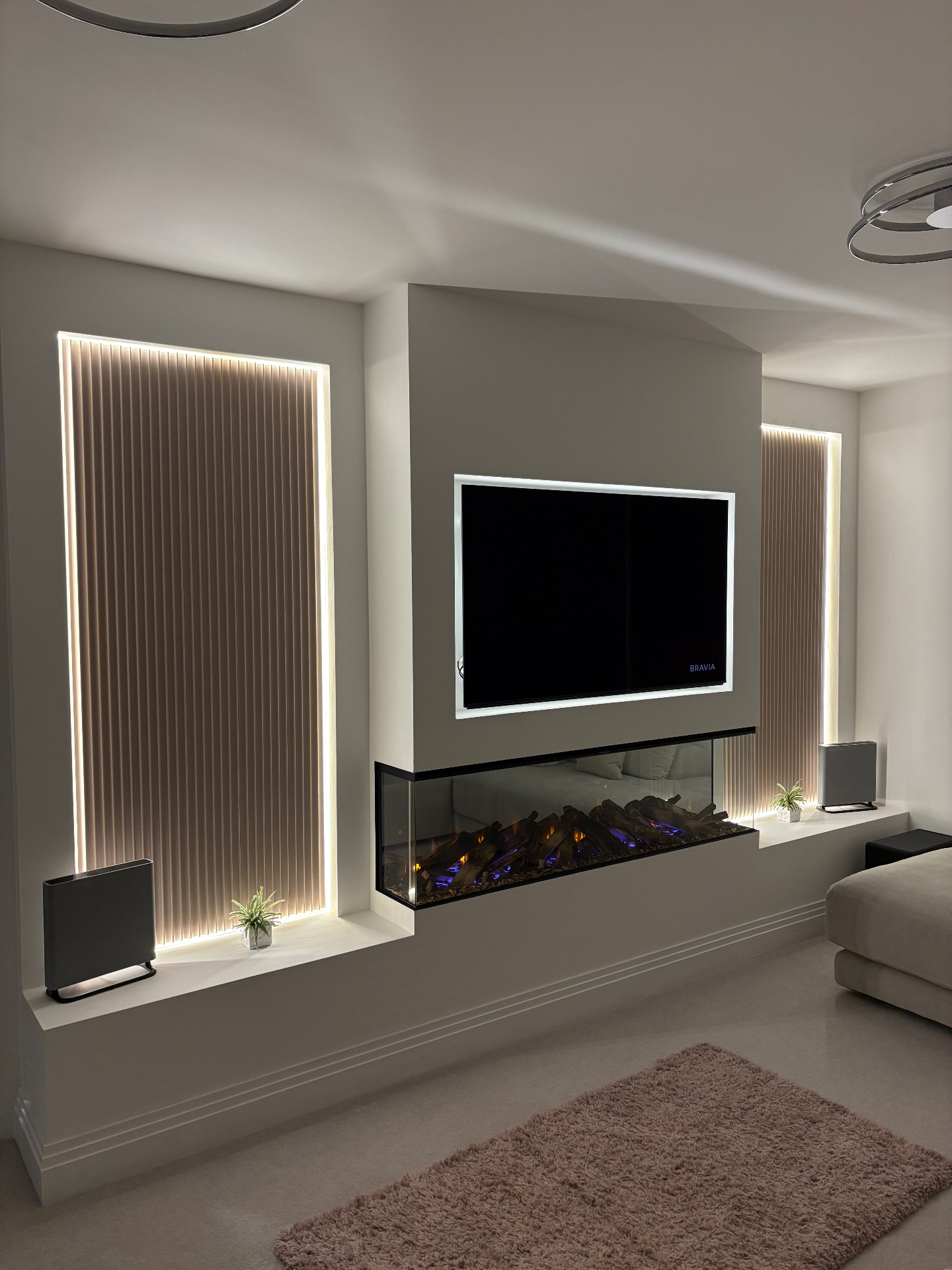 Modern bespoke media wall with integrated fireplace and LED lighting